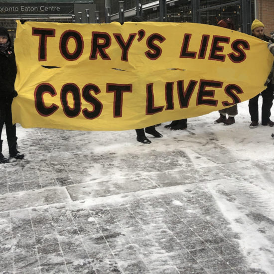 Marchers hold sign saying Tory's lies cost lives